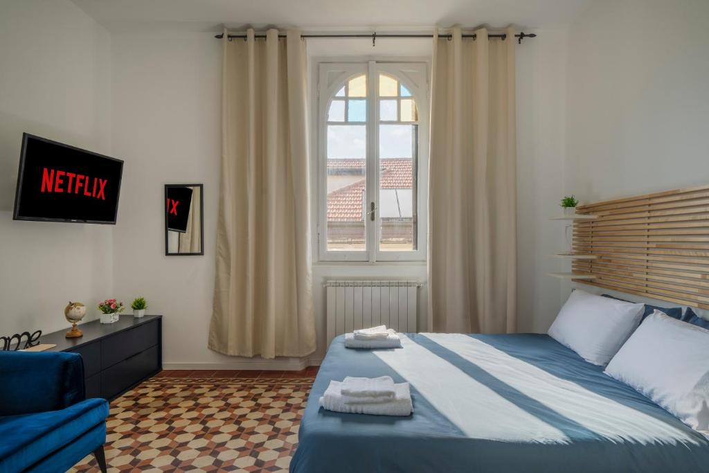 a bedroom with a blue bed and a window at Station 1 min - Monza Center, Milan - Wifi and AC in Monza