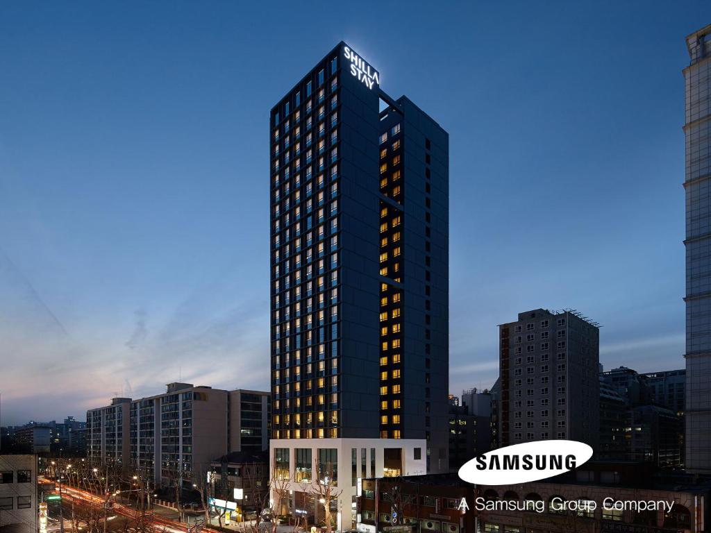 a tall building with lights on in a city at Shilla Stay Seocho Gangnam Station in Seoul