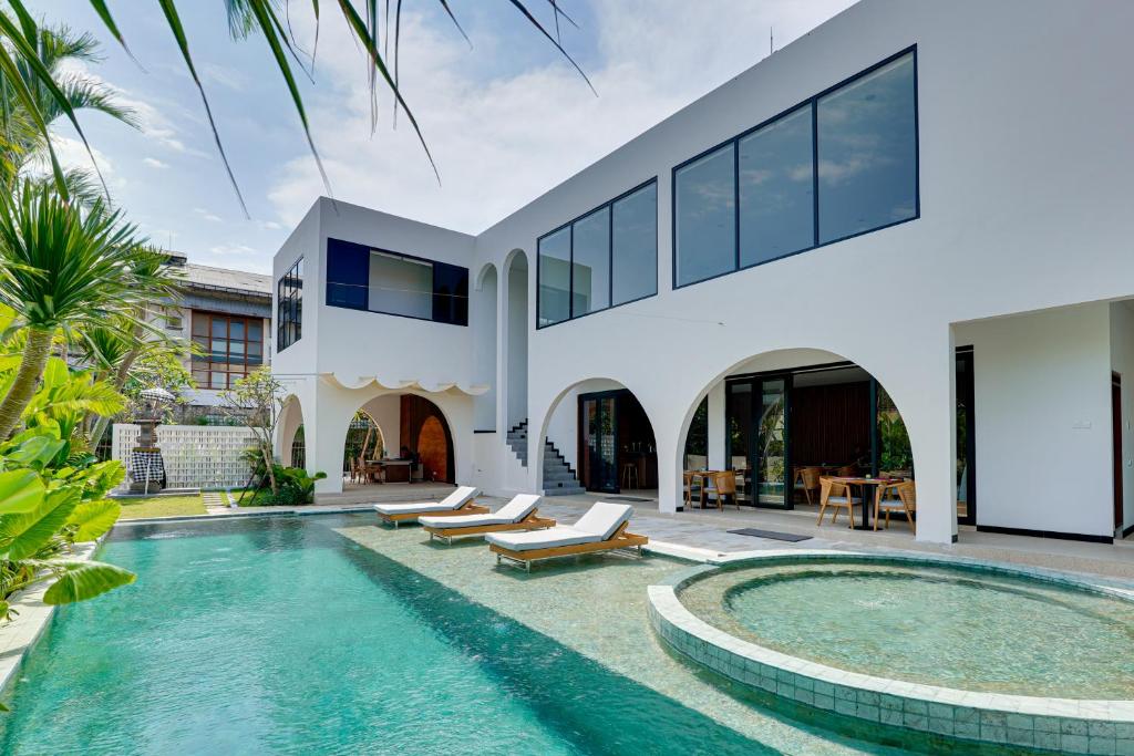 a villa with a swimming pool and a house at Bhatara Villa Sanur in Sanur
