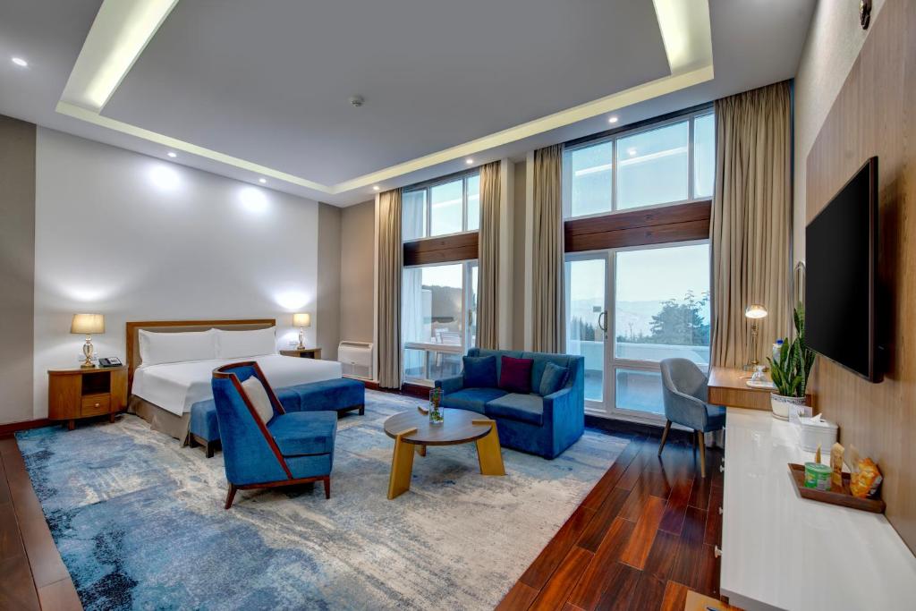 a hotel room with a bed and a tv at Pearl Continental Hotel, Bhurban in Bhurban