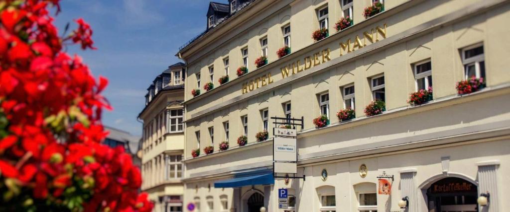 a building with flowers on the side of it at Hotel Wilder Mann Annaberg-Buchholz in Annaberg-Buchholz