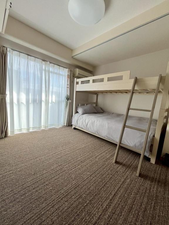ein Schlafzimmer mit zwei Etagenbetten und einem großen Fenster in der Unterkunft Hanazono501 in Niigata