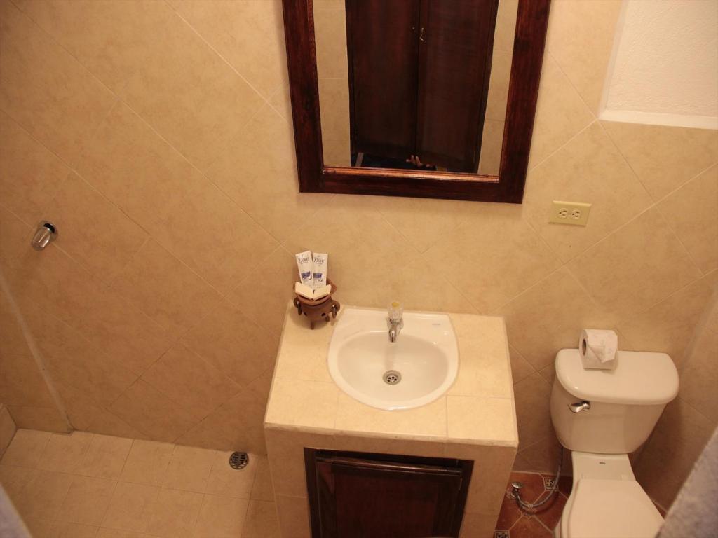 a bathroom with a sink and a toilet and a mirror at Boutique Hotel Maharaja in Granada
