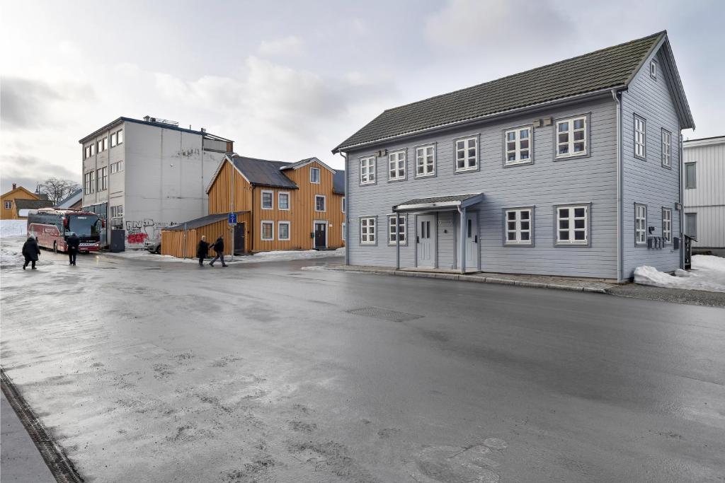 a group of people walking down a street next to buildings at Northstay - Skansegata Apartments, Apartment C l One-Bedroom in Tromsø