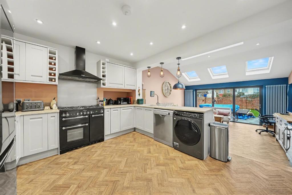 a kitchen with a washer and dryer in it at Finest Retreats - Twickers Townhouse in Whitton