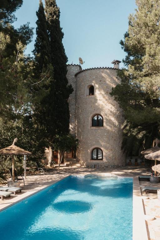 a large swimming pool in front of a castle at Landhotel Can Davero in Binissalem