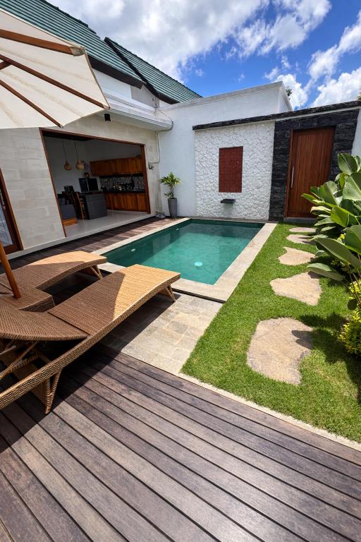 a backyard with a swimming pool and a wooden deck at Moonlight Heaven Villa Ubud 2BR Private Pool in Tampaksiring