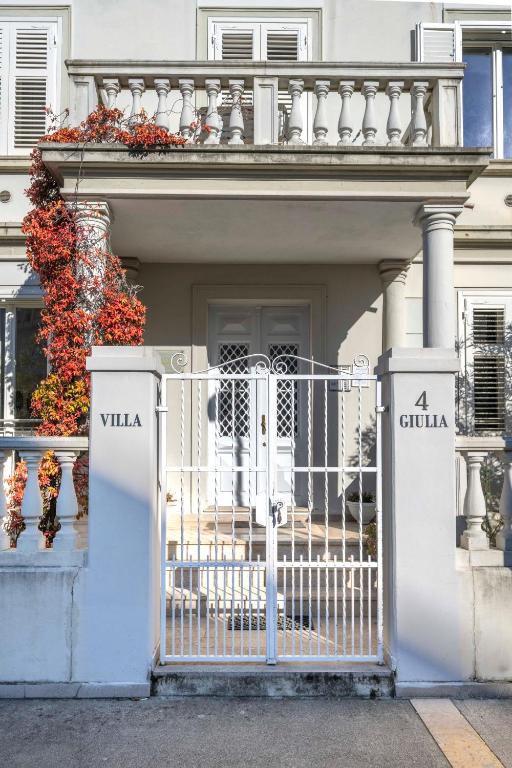 a white house with a gate and a balcony at Residence in Villa Giulia in Grado