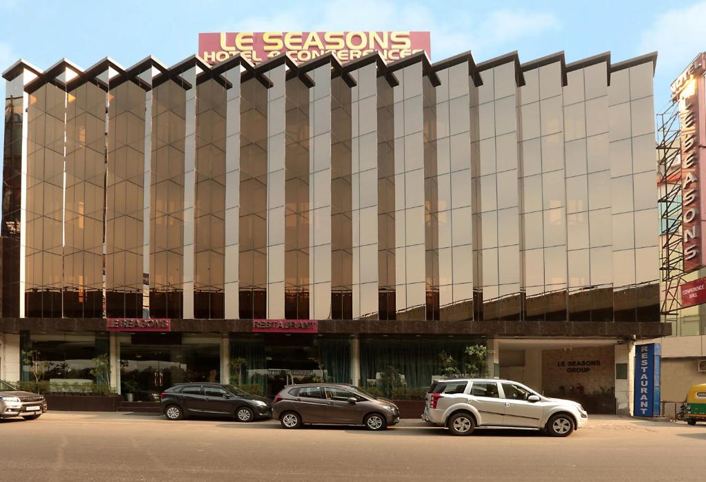 un edificio con coches estacionados frente a él en Airport Hotel Le Seasons New Delhi, en Nueva Delhi