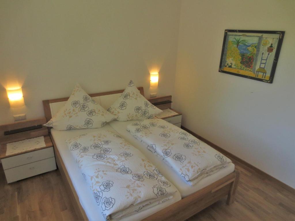 een slaapkamer met een bed met witte en blauwe kussens bij Ferienwohnungen Hödingen, Bernhard Vogler in Überlingen