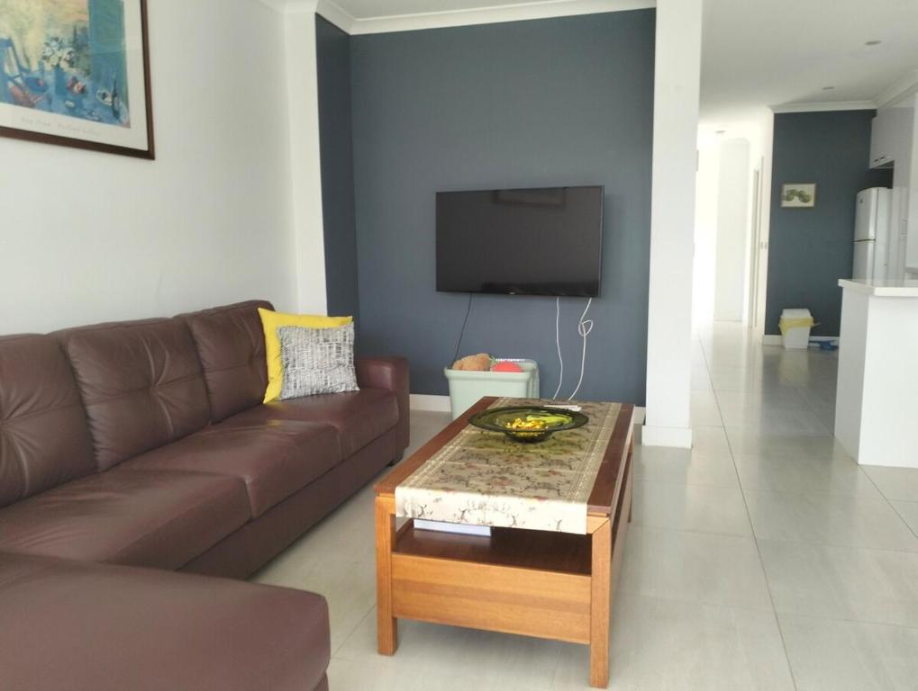 a living room with a brown couch and a coffee table at Comfort and good value in Melton South