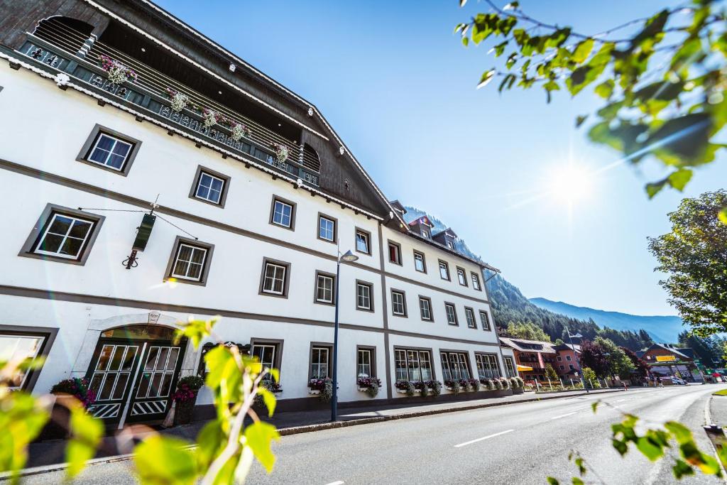 a large white building on the side of a street at Landhotel Postgut - Tradition seit 1549 in Tweng