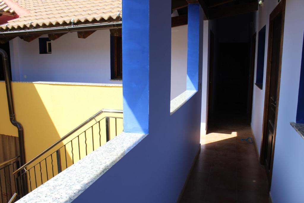 a blue and yellow building with a door and a hallway at Pensión Media Luna in Andorra