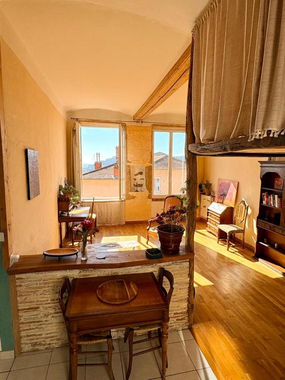 a living room with a table and a room with a couch at amazing view appartment in Lyon