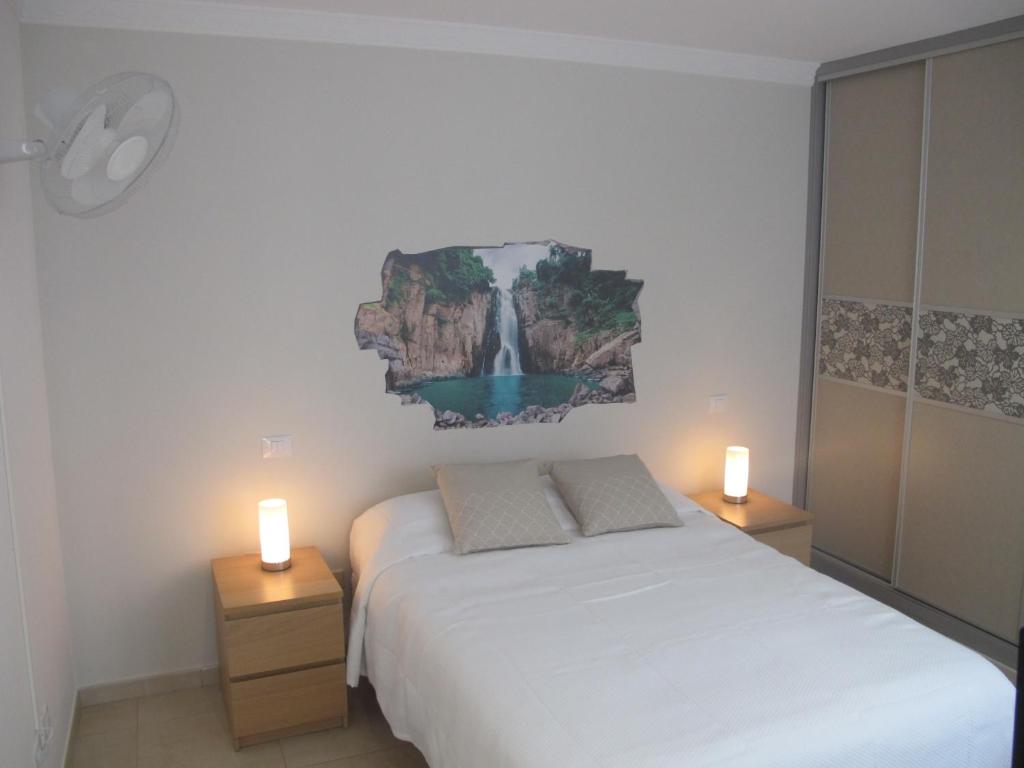 1 dormitorio con 1 cama y 2 velas en las mesas en Apartamento Kings Vegueta, en Las Palmas de Gran Canaria