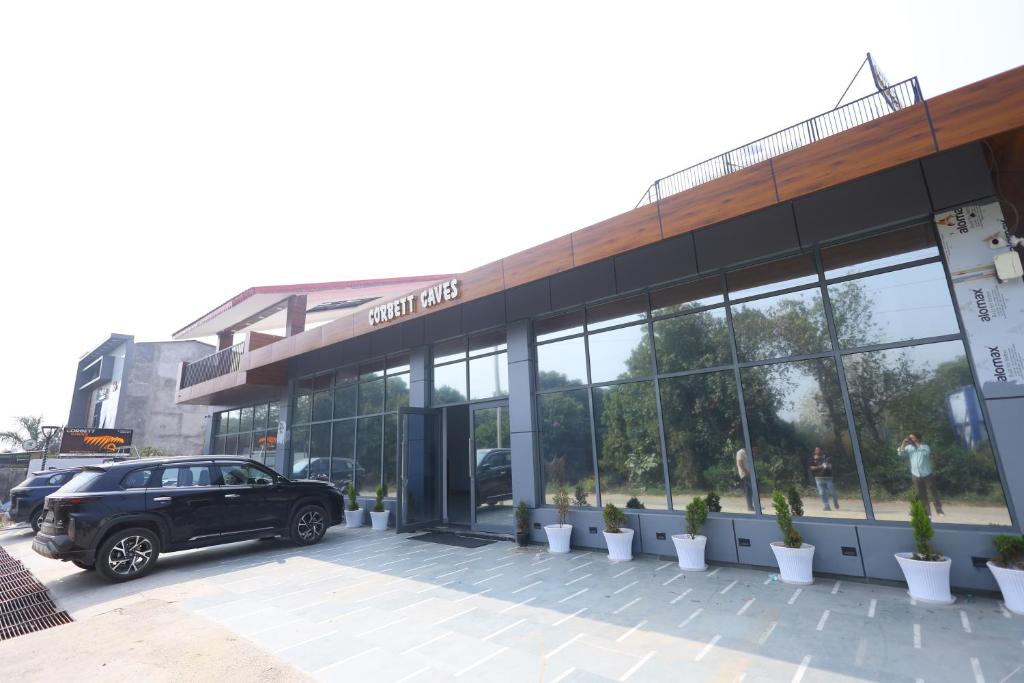 a black car parked in front of a building at Corbett Caves in Rāmnagar