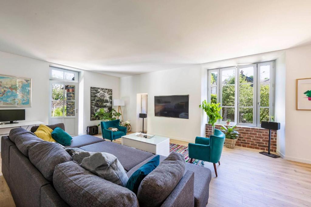 a living room with a couch and chairs and windows at Moulin in Vitré