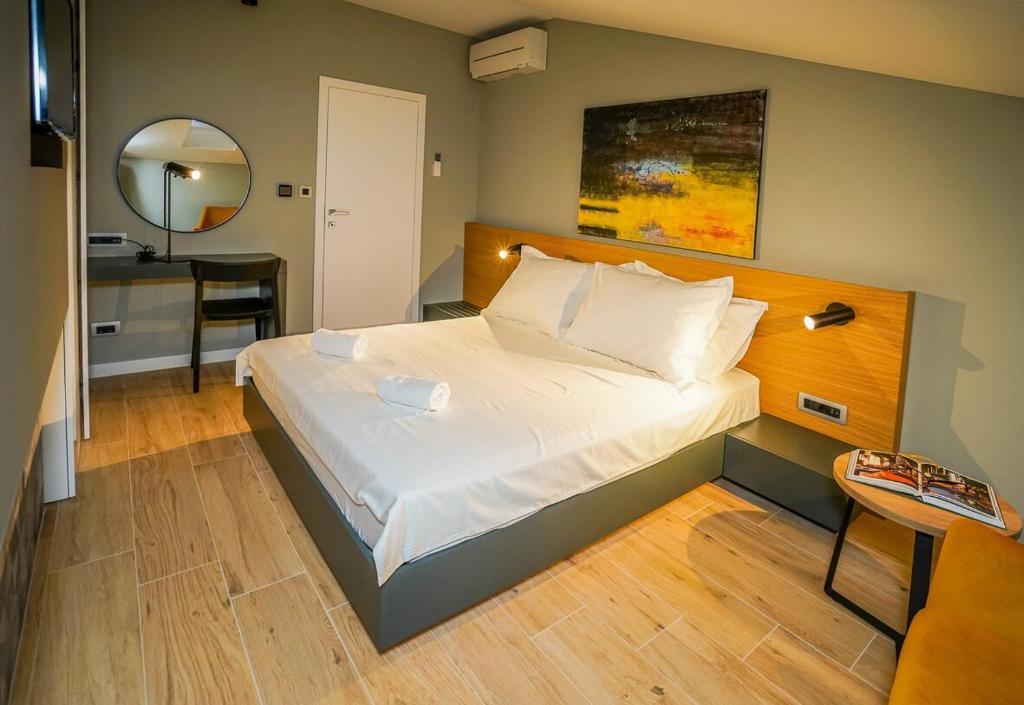 a bedroom with a large bed with a desk and a mirror at Seaview Villa Rajmond in Podstrana
