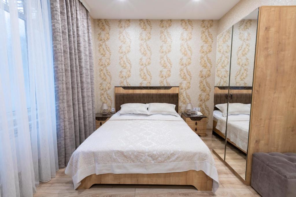 ein Schlafzimmer mit einem Bett und einem Spiegel in der Unterkunft MidCity Hotel in Baku