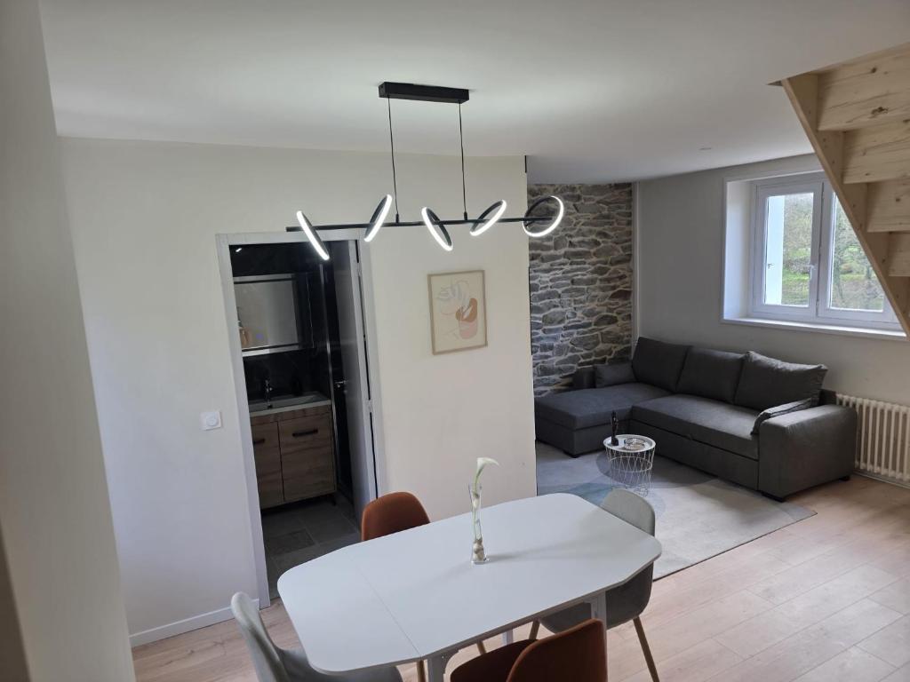 a living room with a white table and a couch at L'hyère in Carhaix-Plouguer