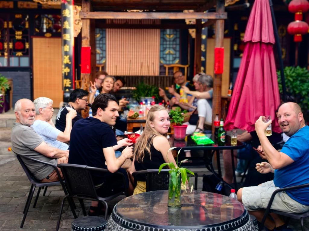 a group of people sitting at tables in a restaurant at Pingyao Xinglongyi Inn in Pingyao