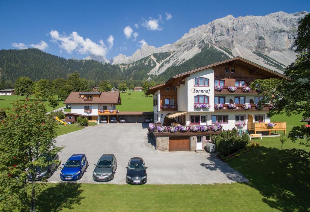 un grupo de coches estacionados frente a un edificio en Sonnhof, en Ramsau am Dachstein