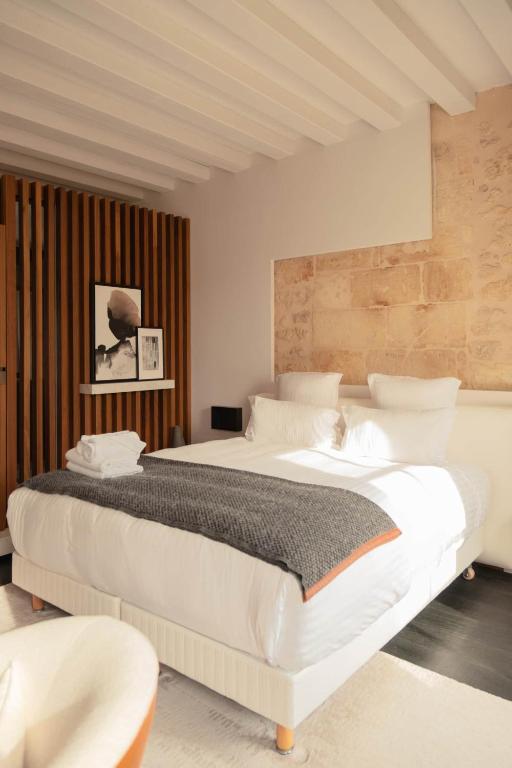 a bedroom with two large white beds in it at Château Fonroque - Camomille in Saint-Émilion