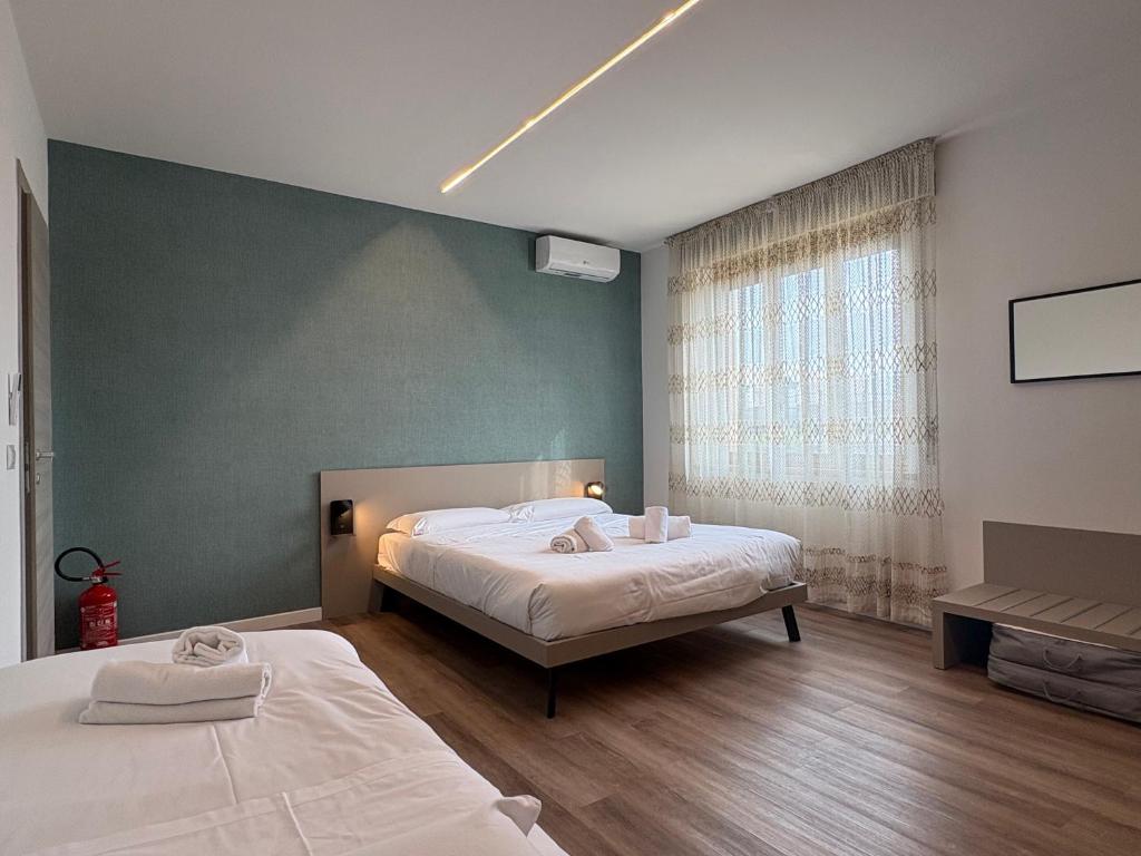 a bedroom with two beds and a window at Cozy Apartments and Rooms in Caselle di Sommacampagna