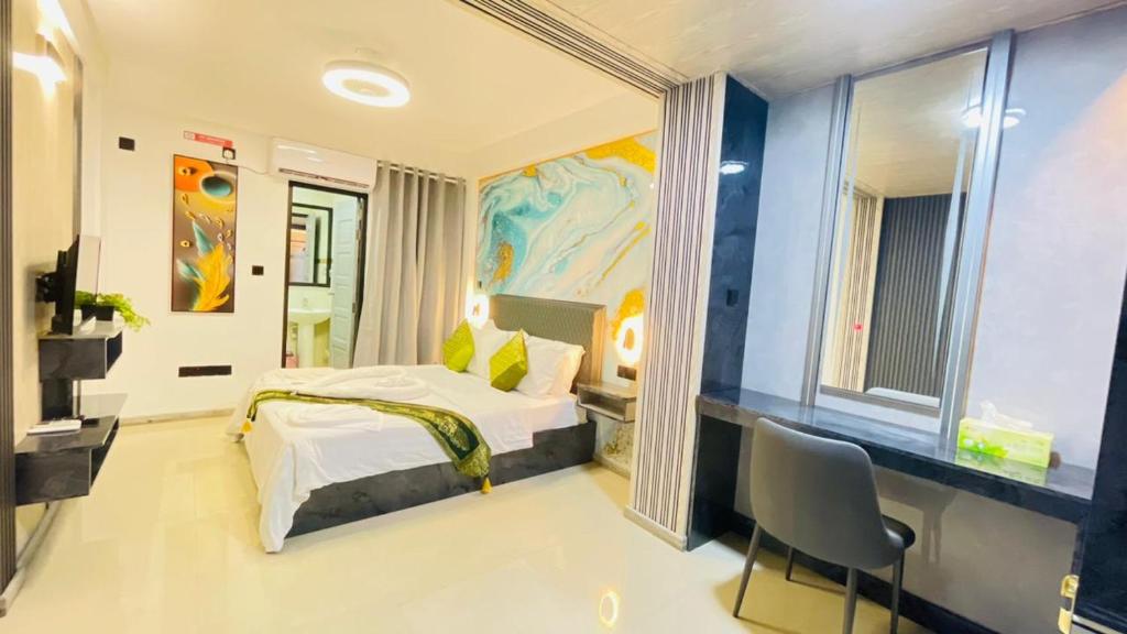 a bedroom with a bed and a desk and a chair at HS Miracle View in Hulhumale