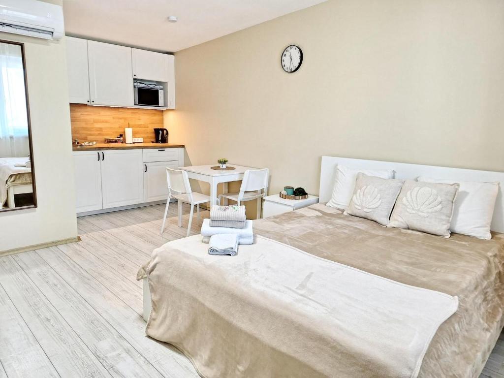 a bedroom with a large bed and a kitchen at Dunes Trail 4 in Melnragė