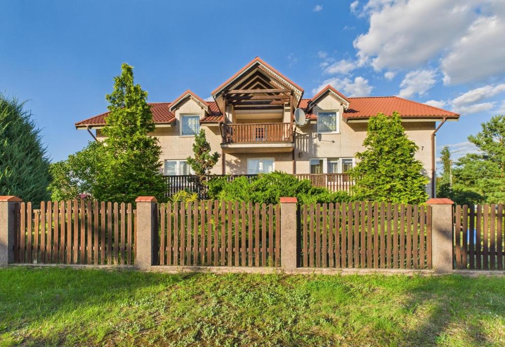 a wooden fence in front of a house at Asetech Sandra in Pasym