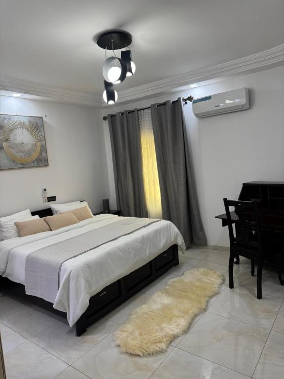 a bedroom with a large bed and a piano at Home away from Home in Komé