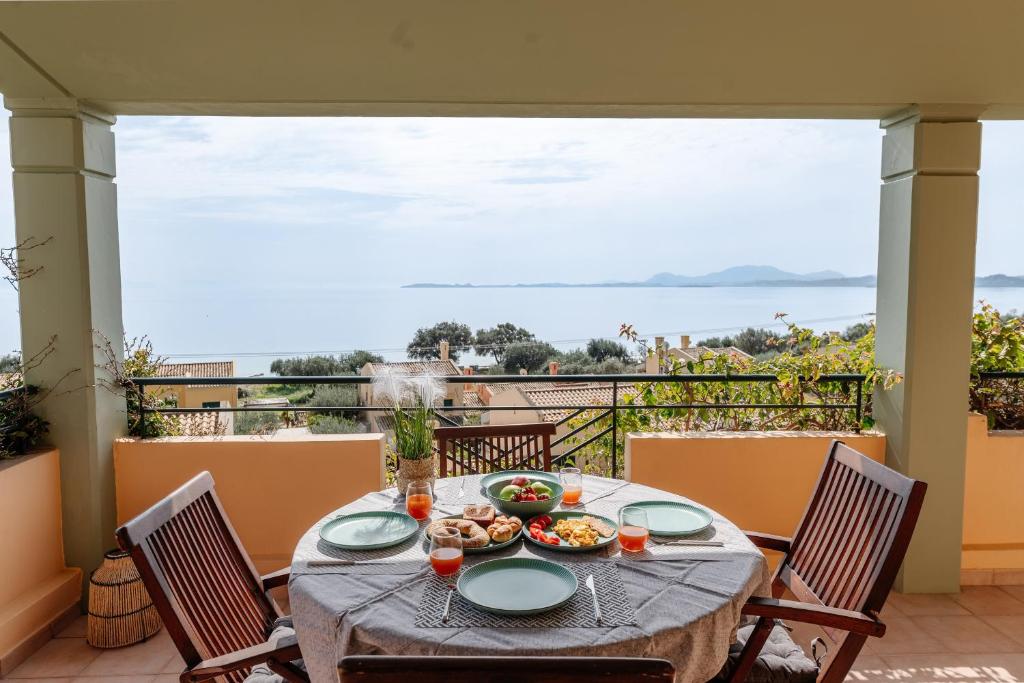 a table on a balcony with a view of the ocean at CorfuLevante Sea View in Barbati