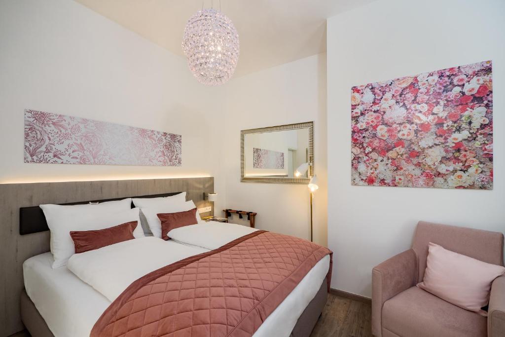 a bedroom with a bed and a chair at Boutique Hotel Rose in Baden-Baden