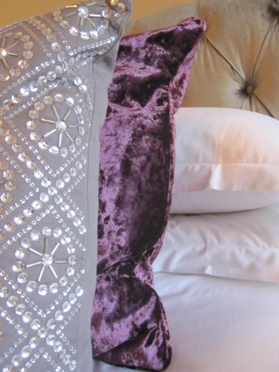 almohada morada en una cama junto a una almohada blanca en Druid House en Christchurch