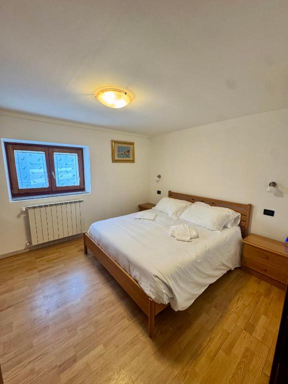 a bedroom with a large bed with white sheets at Casa Flory in Verbania