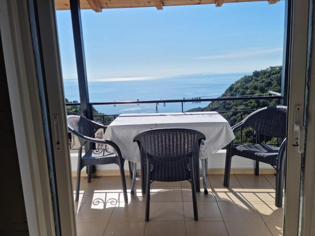 a table and chairs on a balcony with a view of the ocean at Alban Apartament in Lukovë
