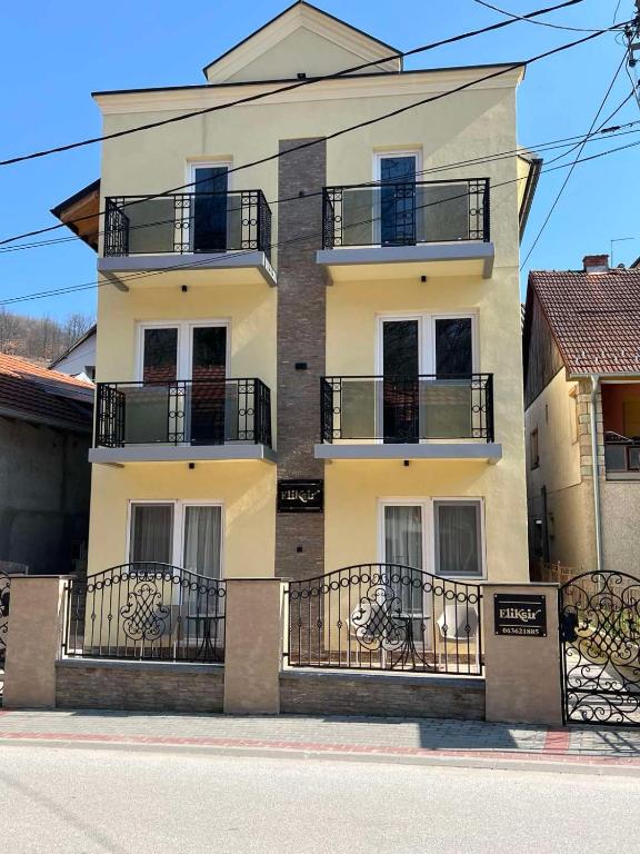 a white building with balconies on the side of it at Eliksir in Gornja Trepča