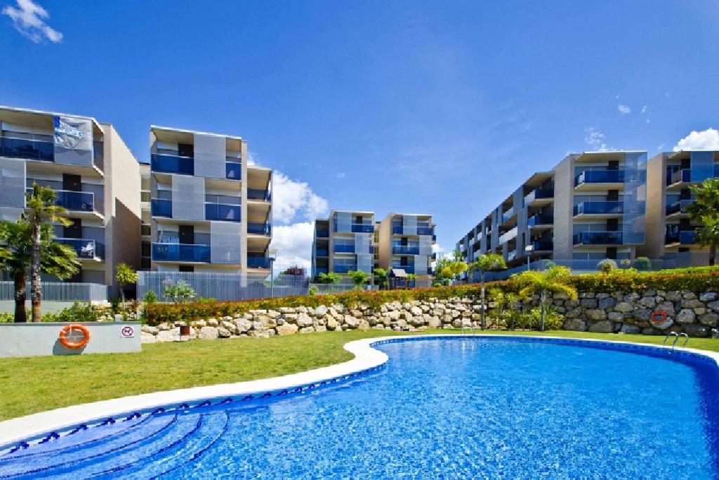 una piscina frente a algunos edificios de apartamentos en UHC Paradise Village Family Complex, en Salou