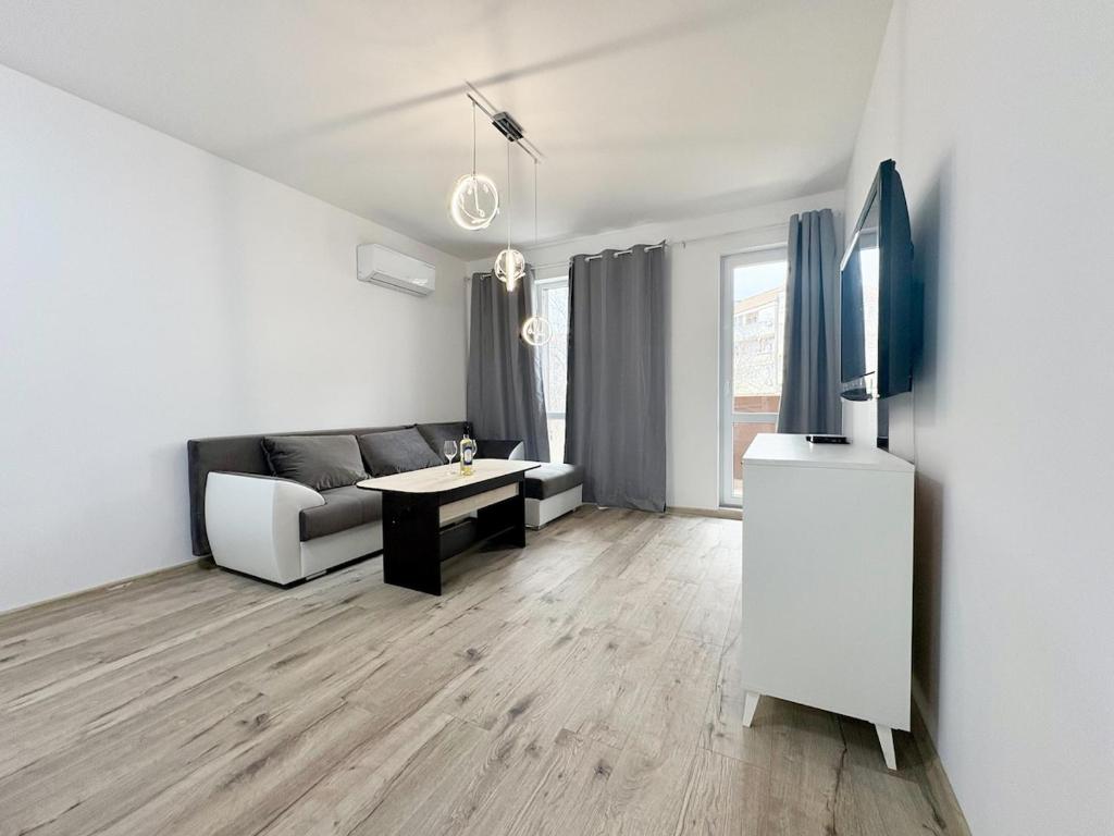 a living room with a couch and a tv at Modern Nest Varna - free parking in Varna City