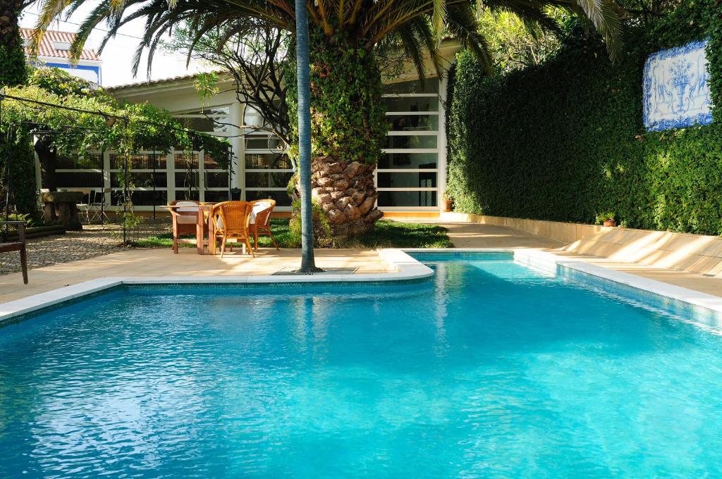 a blue swimming pool in a yard with a table at Casa Do Foral in Rio Maior