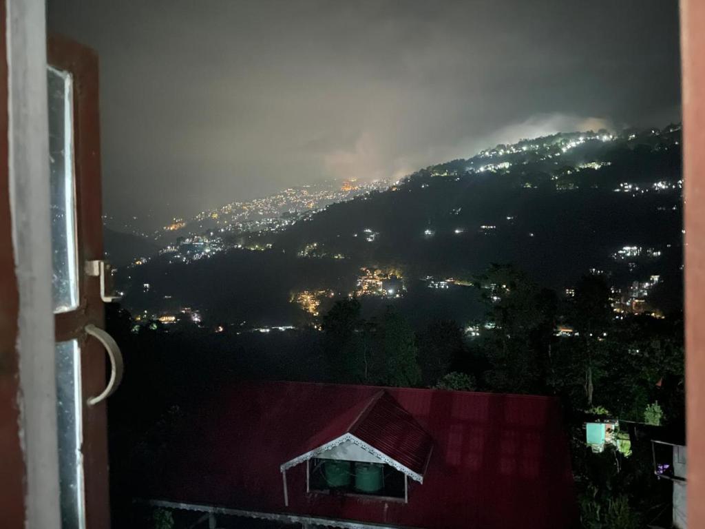 a view of a city from a window with a mountain at Bagaicha Farms in Tādong