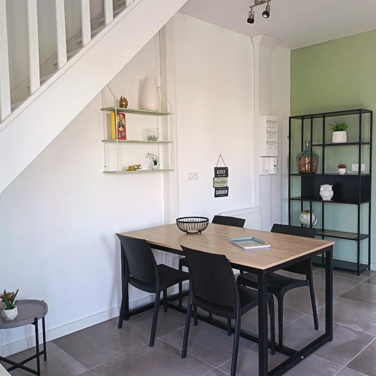 a dining room with a wooden table and chairs at Logement 1 - proche Le Mans in Aigné