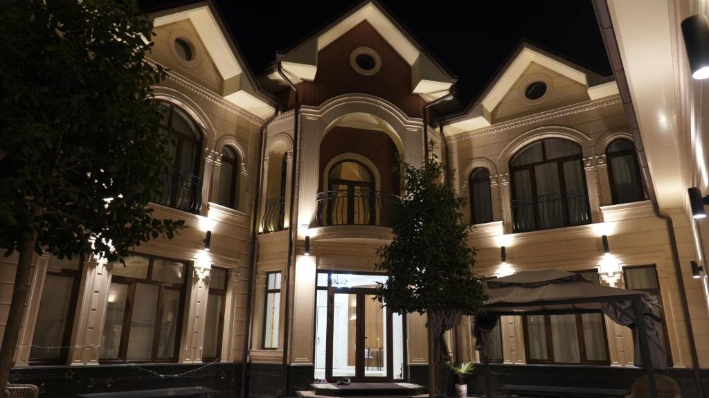 a large white building with a tree in front of it at Symphony Boutique in Tashkent