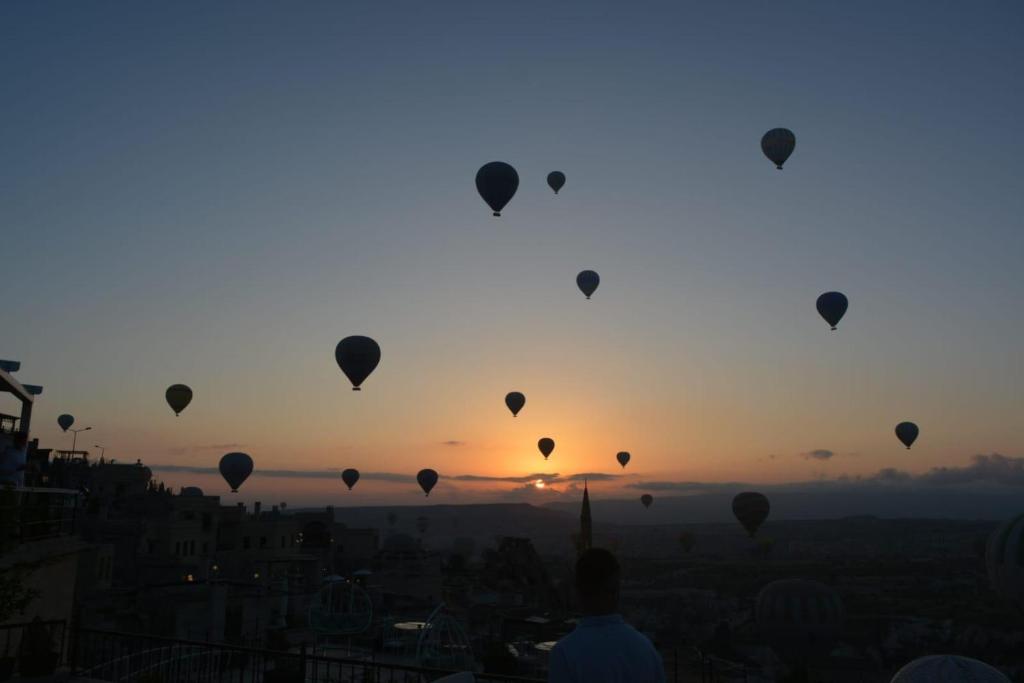 a group of hot air balloons in the sky at sunset at La Vie Cappadocia Cave in Nevşehir