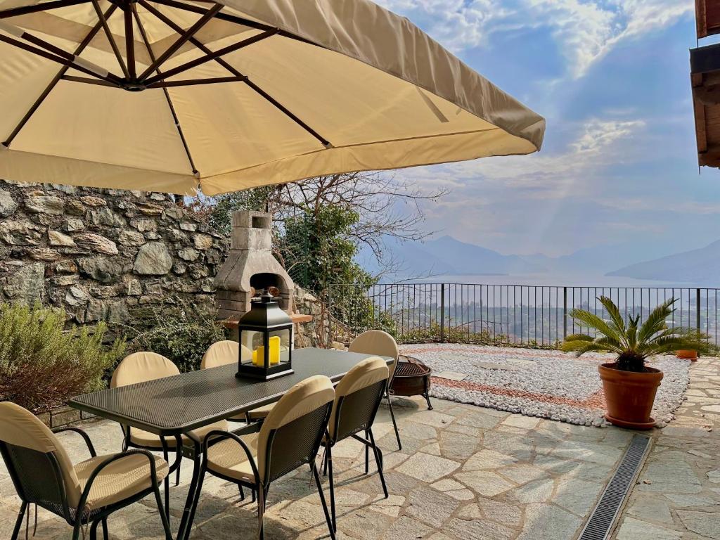 a table and chairs with an umbrella on a patio at Terrazza fra lago e monti in Gravedona