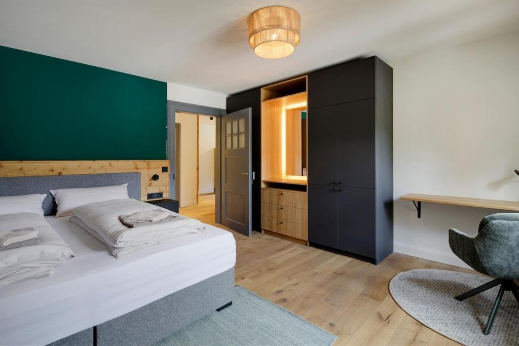 a bedroom with a bed and a desk and a chair at Top sanierte, gehoben ausgestattete Wohnung für 2-4 Personen in Baudenkmal in Feldberg