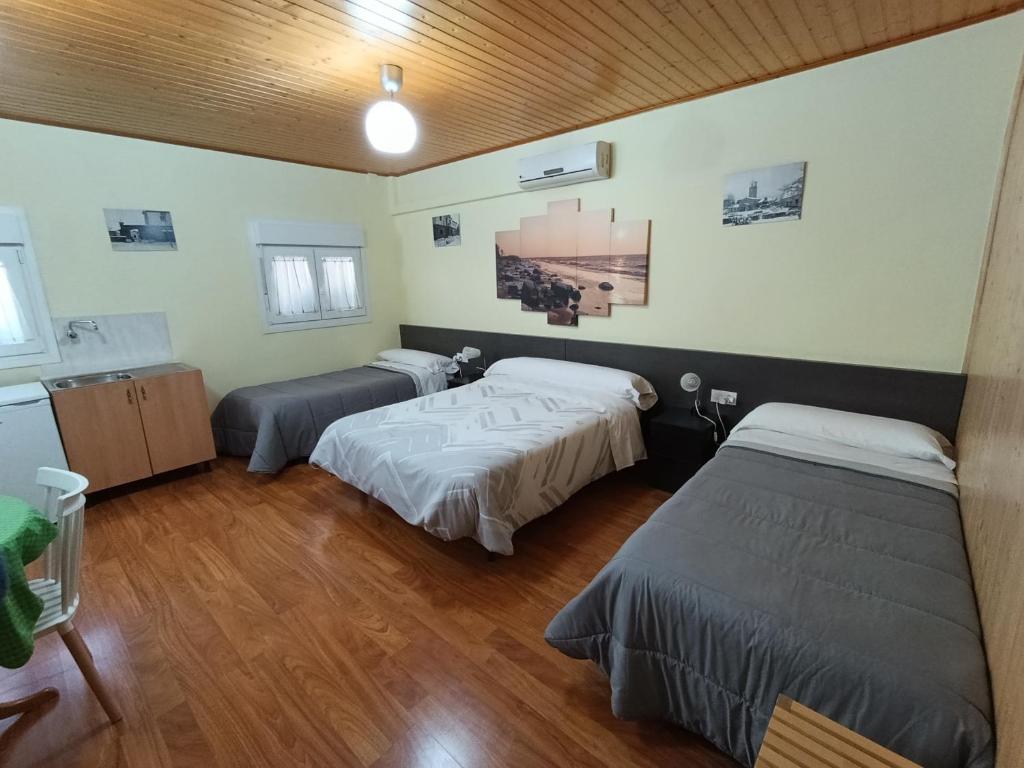 a room with two beds and a sink in it at Habitación independiente en Casa Rural Javier in Valmuel