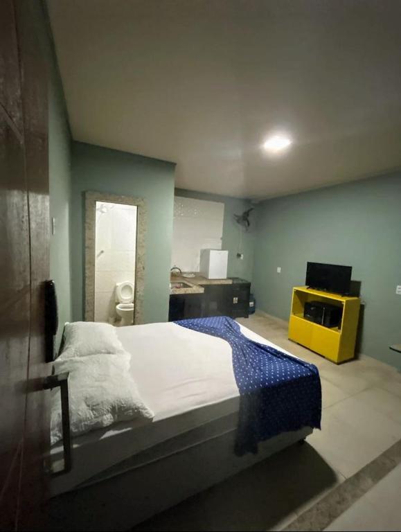 a bedroom with a bed and a yellow dresser at kit net master simple in Divinópolis