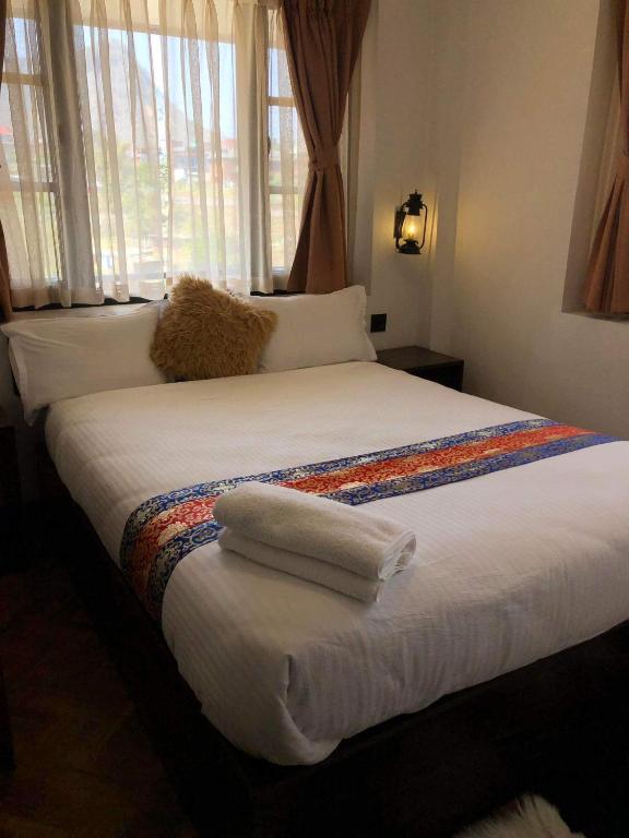 a bedroom with a large bed with towels on it at Himalayan Hideaway in Bākhri Kharka